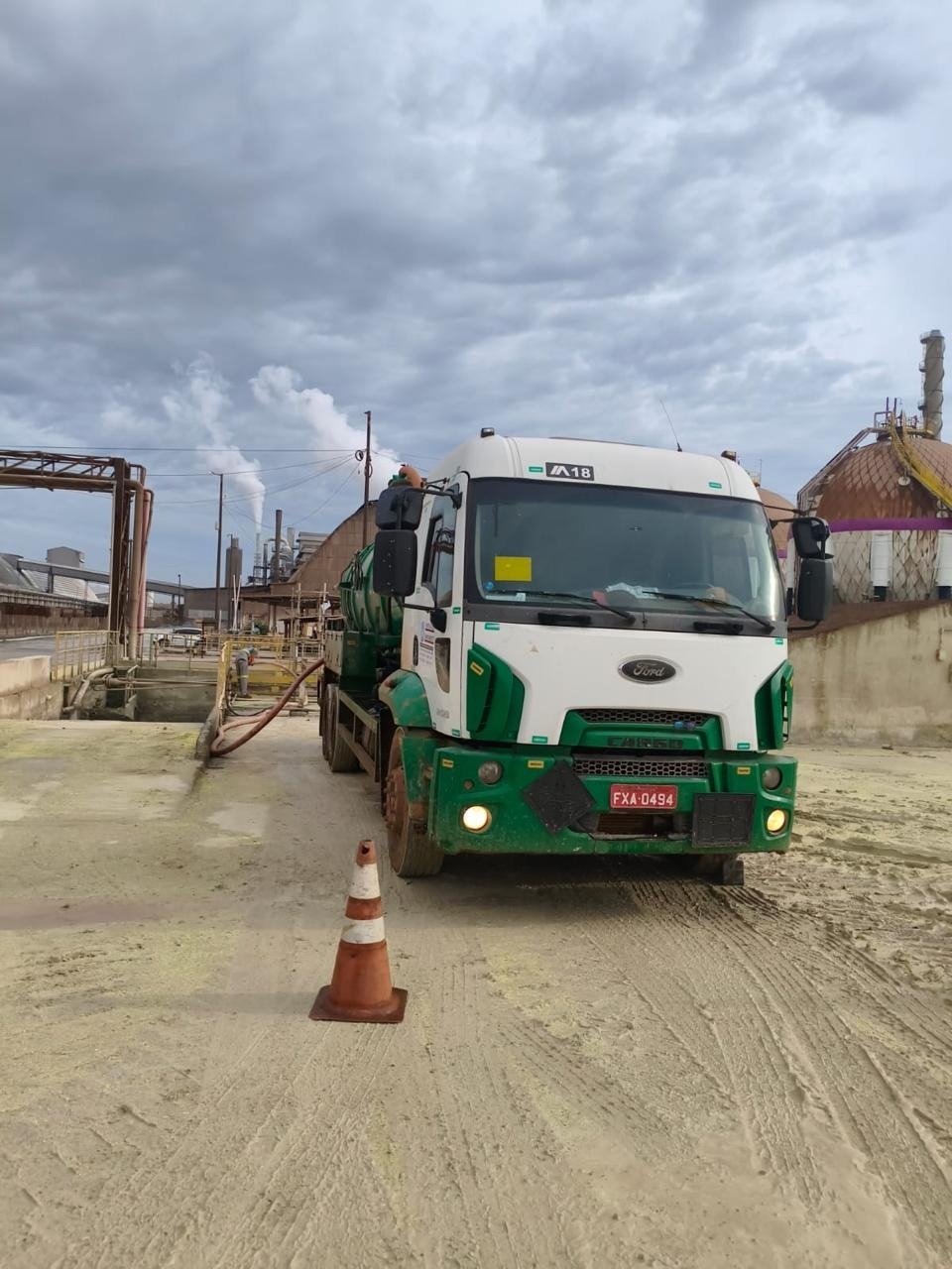 Caminhão vácuo Ford Cargo verde em unidade industrial