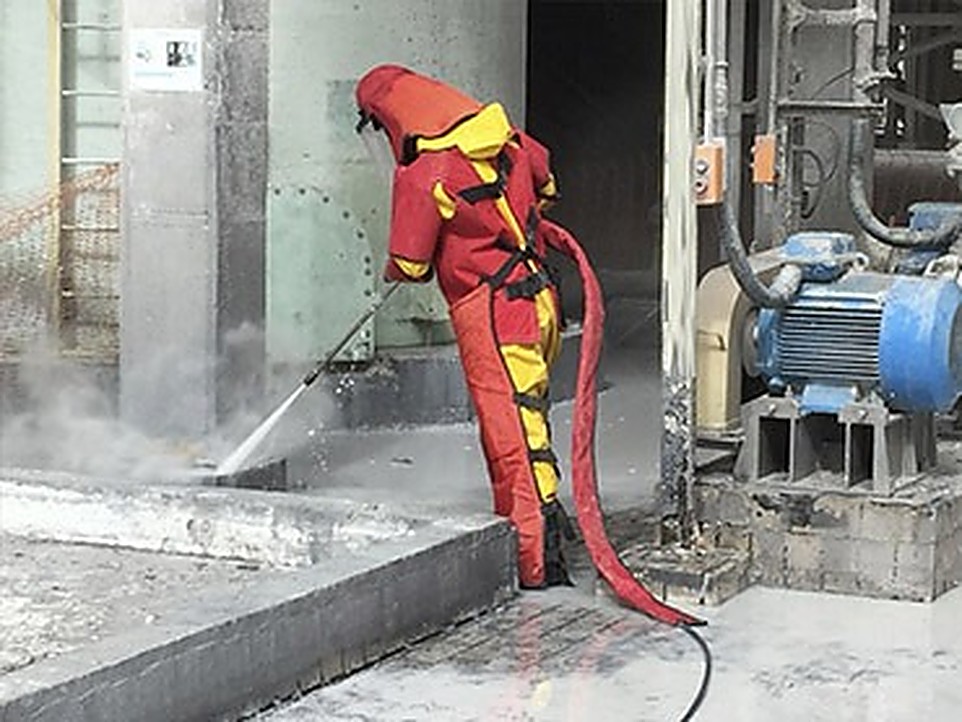 Técnico com traje de proteção realizando hidrojateamento