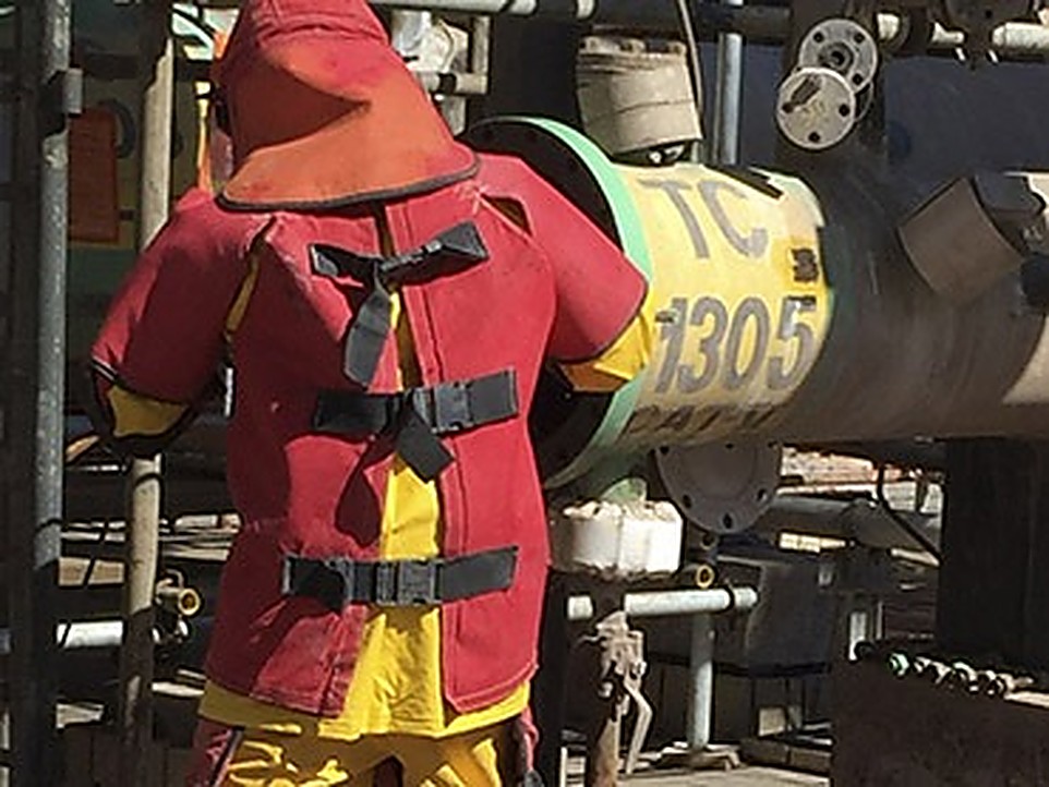 Técnico com traje de proteção térmica em planta industrial